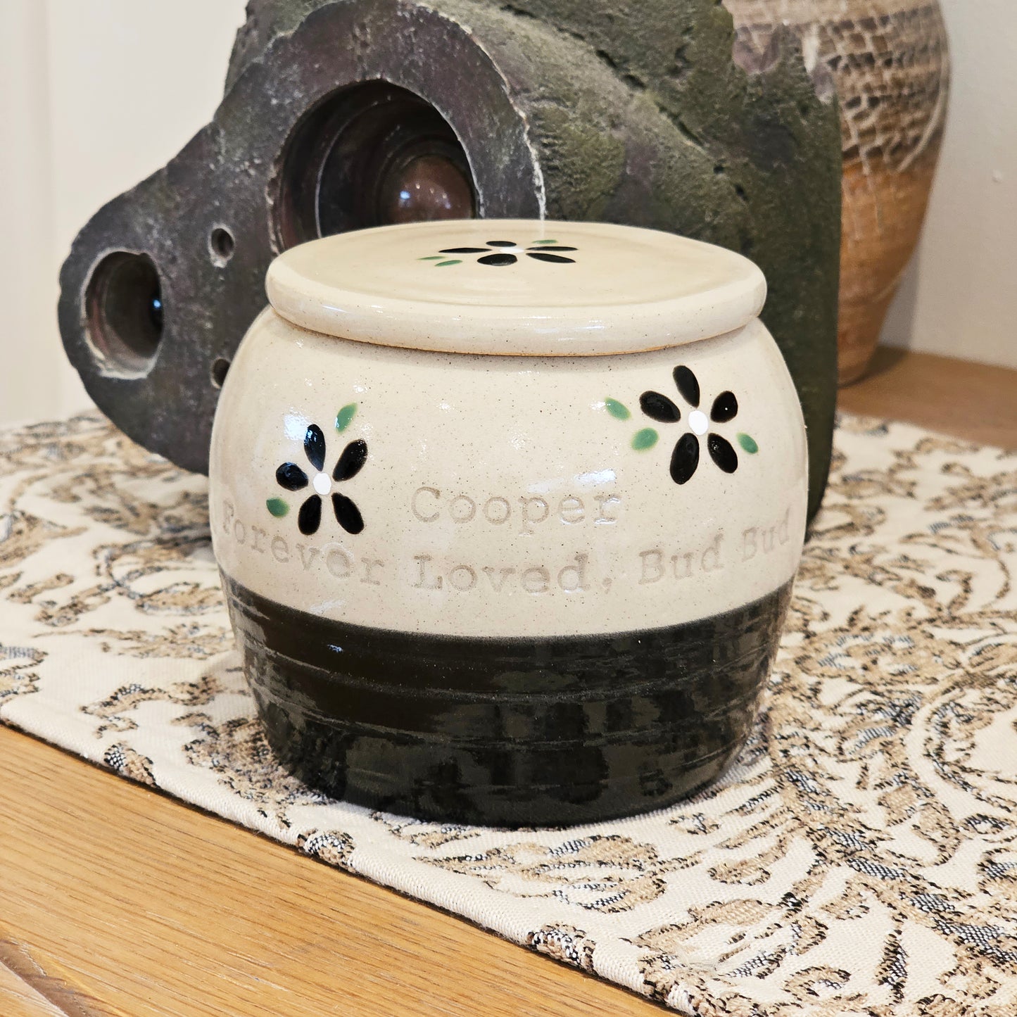 Animal urn on table with 'Cooper, Forever loved, Bud Bud' inscribed in the pottery