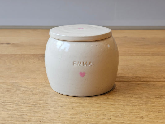 Ceramic pet urn featuring a simple pink heart on the front and lid, with the words 'Emma' engraved on the fron