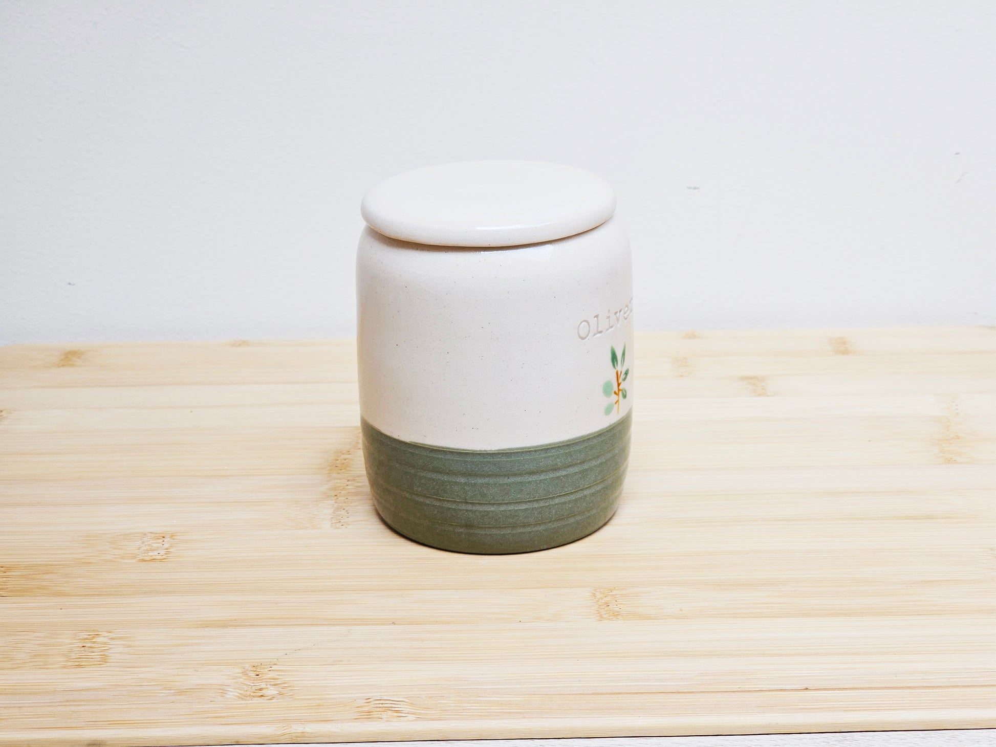 Ceramic jar with a lid on a wooden surface
