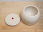 Personalised ceramic pet cremation urn with daisy artwork and ladybug detail – handmade in UK studio