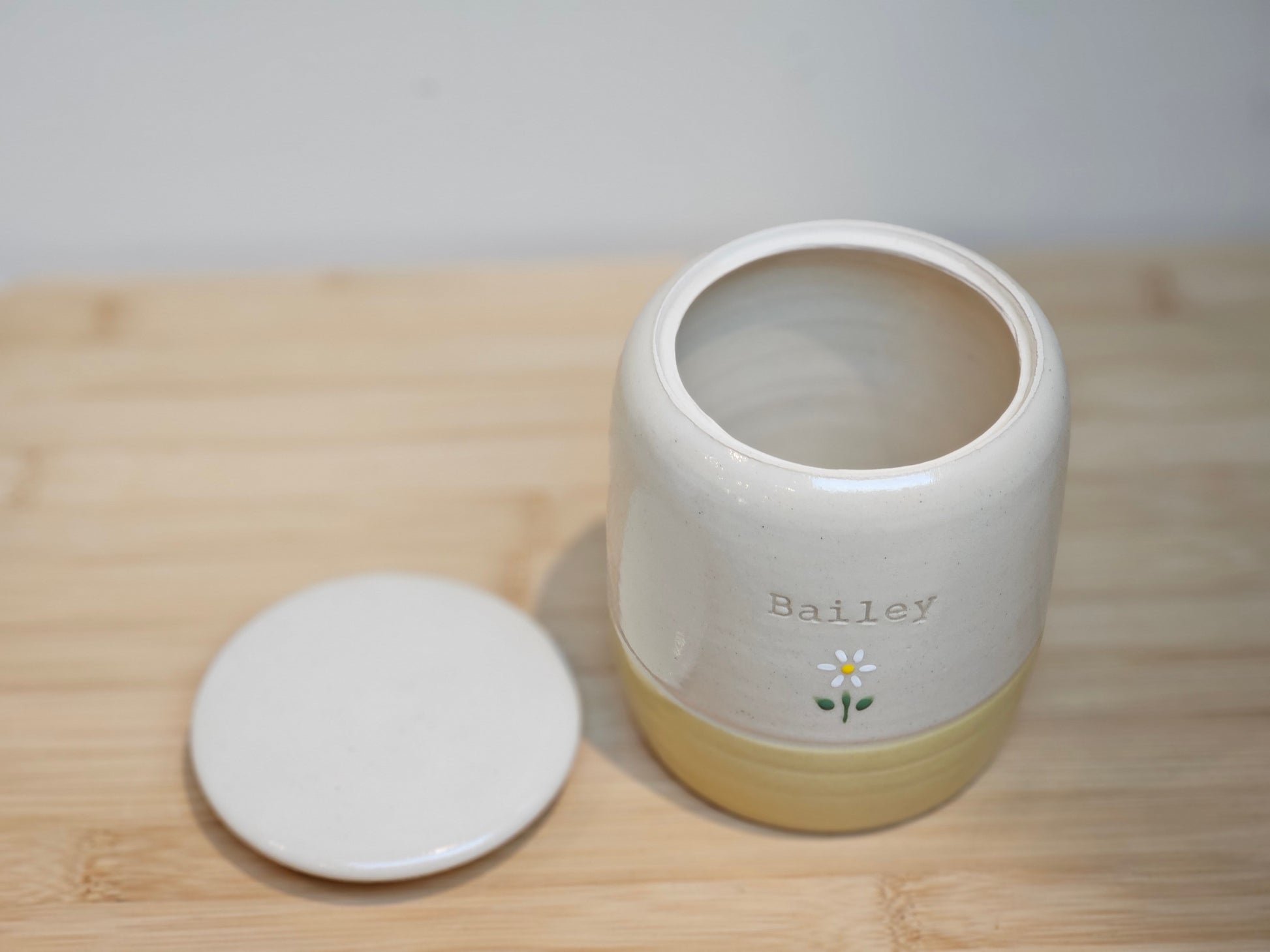 Top view of handcrafted pet urn lid with delicate hand-painted flowers and smooth glossy finish.