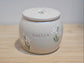 Handmade ceramic pet urn with hand-painted white lilies and personalised name detail