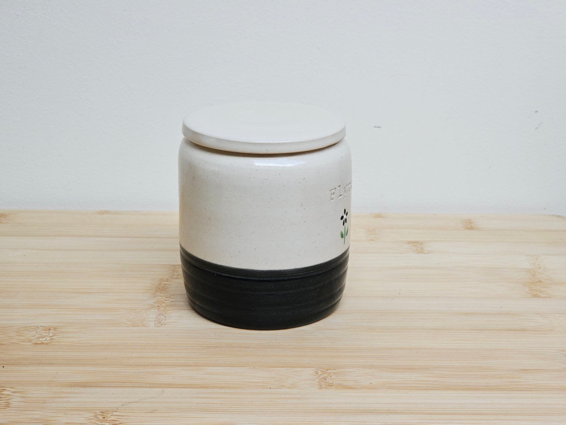 Custom pet urn with black base on a wooden surface. Personalised gift for pet loss.