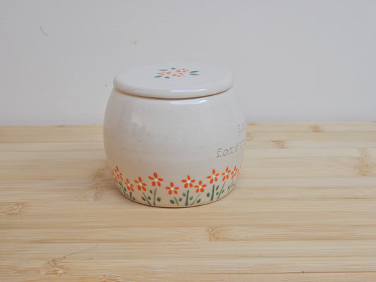 Handmade ceramic pet urn with orange flowers hand-painted around the entire bottom, perfect personalized memorial keepsake for pets.