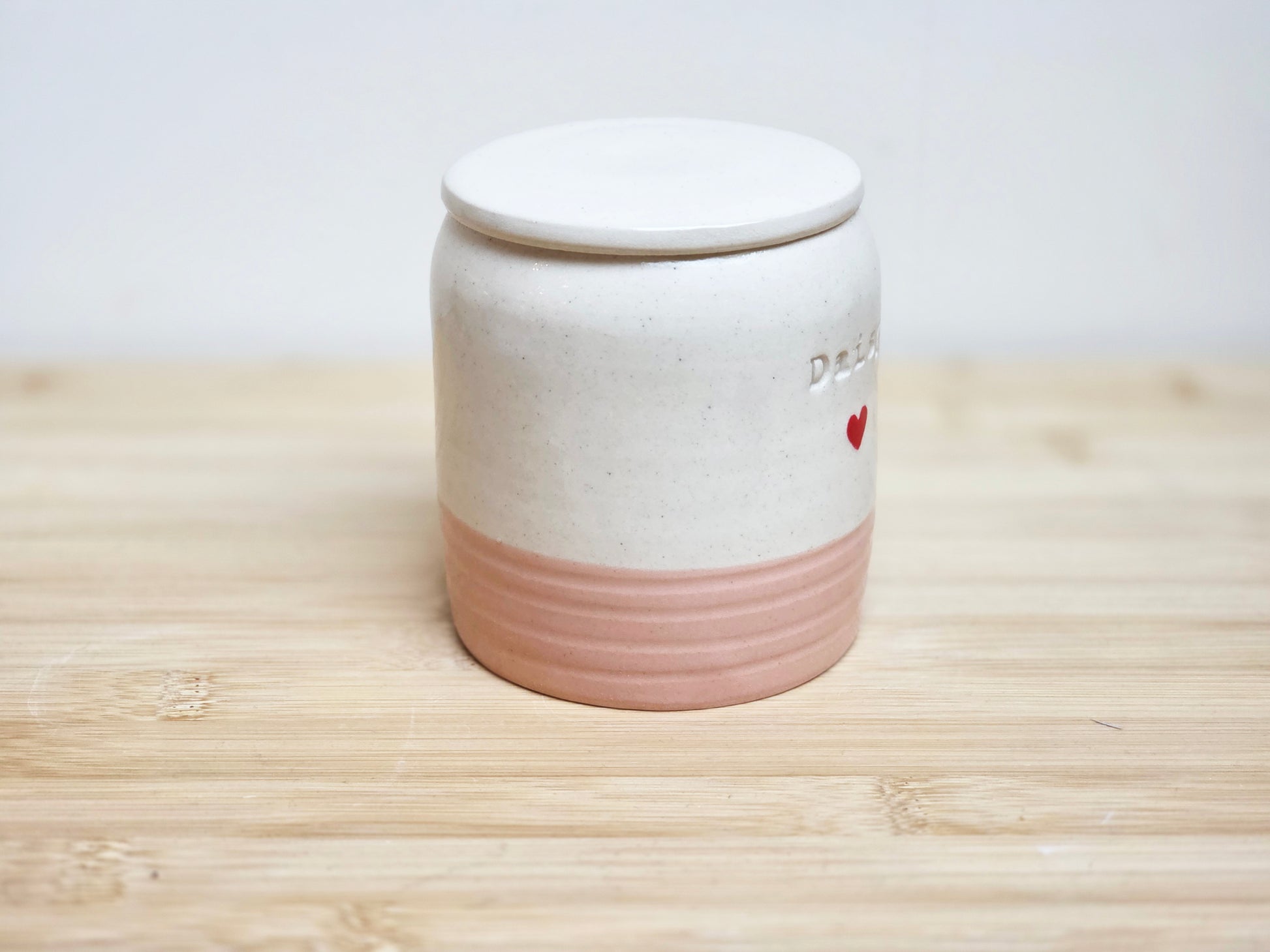Ceramic jar with a lid on a wooden surface