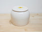 Custom pet urn with a lid featuring a sunflower design on a wooden surface.