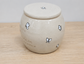 White ceramic urn with white butterfly designs and text on a wooden surface